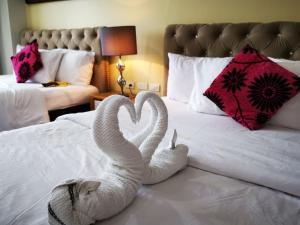 two swans made out of towels sitting on a bed at CatherinePlace Tagaytay - Wind Residences Tower 3 in Tagaytay