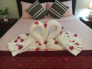 2 cigni fatti di asciugamani su un letto di Venezia Suites Resort Panglao a Panglao
