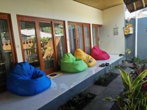 a row of colorful bean bags sitting on a porch at Backpackers Home Amed in Amed