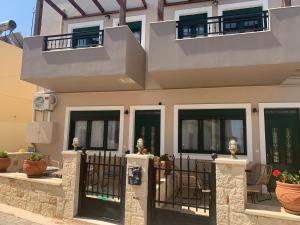 a house with black doors and a fence at Irini Apartment Piskopiano, Hersonissos #2 in Hersonissos