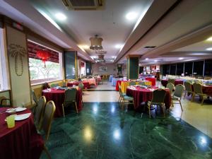 a restaurant with red and yellow tables and chairs at Hotel Sandakan in Sandakan