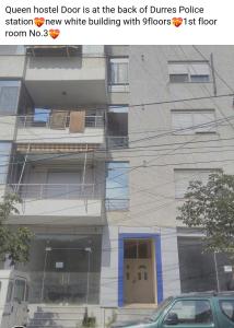 uma foto de um edifício com um sinal que diz a porta do hospital Queen está em em Queen Hostel em Durrës