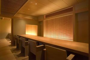 a row of chairs in a room with a long bar at Kaichoro in Shibukawa