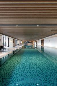 a swimming pool with a tile floor in a building at Dongguan DongCheng International Hotel - Free shuttle bus for Canton Fair in Dongguan