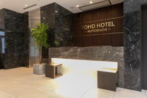 a lobby of a hotel with a table and a plant at Toho Hotel Namba Motomachi in Osaka
