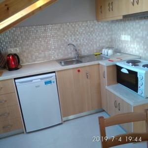 una pequeña cocina con fregadero y lavavajillas en Ermones Mare, en Ermones