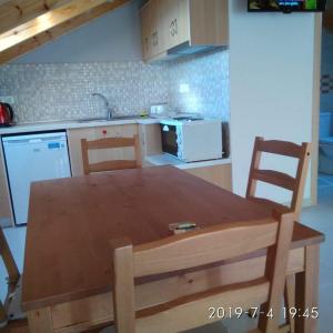 a kitchen with a wooden table and chairs in it at Ermones Mare in Ermones