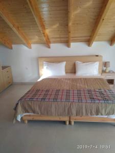 a large bed in a room with a wooden ceiling at Ermones Mare in Ermones