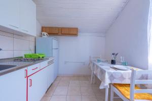 eine Küche mit einem Tisch und einem Herd Top-Backofen in der Unterkunft Apartmani Mirko A1 in Molat