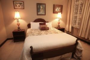 a bedroom with a large bed with two lamps at The Grand Hotel Wanganui in Whanganui