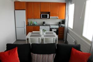 a kitchen with a table with red pillows at Kotimaailma Apartments Joensuu - Koskikatu 11 in Joensuu