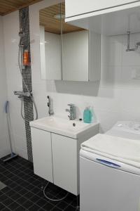 a white bathroom with a sink and a shower at Kotimaailma Apartments Joensuu - Koskikatu 11 in Joensuu