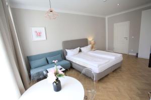 um pequeno quarto com uma cama e um sofá em Zollikof Aparts - Sauna & Studioapartments em Leipzig