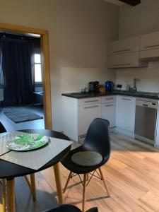 a kitchen with a table and two chairs and a table and a tableablish at Browarna 1 Apartamenty przy Rynku Racibórz in Racibórz