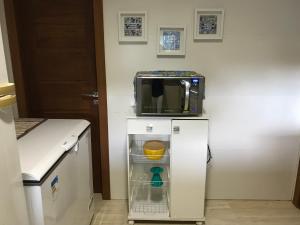 a microwave sitting on top of a refrigerator in a kitchen at Casa Estância do Mar in Olivença