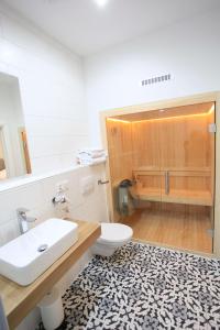 La salle de bains est pourvue d'un lavabo, de toilettes et d'une douche. dans l'établissement Zollikof Aparts - Sauna & Studioapartments, à Leipzig