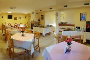 a restaurant with tables and chairs with white tablecloths at Family Hotel Vega in Saints Constantine and Helena