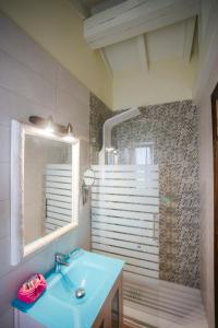 a bathroom with a blue sink and a shower at Posada Las Tres Mentiras de Santillana del Mar in Santillana del Mar