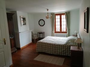 1 dormitorio con cama y ventana en Aux Trois Damoiselles, en Beuvron-en-Auge