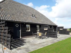 une cabine noire avec une terrasse et une table dans l'établissement Nuuverstee, à Borger