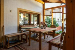 a dining room with a table and chairs and windows at Landhaus Gasser in Wenns