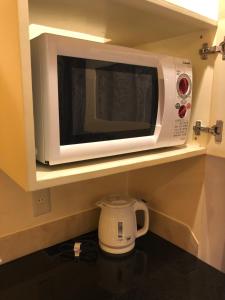 a white microwave on a shelf in a kitchen at Restay Puchi Nagasaki Club (Adult Only) in Nagasaki