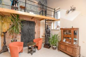 a living room with orange chairs and a loft at Red Tower Apartments in Palanga