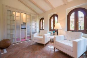 sala de estar con 2 sillas blancas y mesa en Oriental Apartment Gardens Views 2 pax en Sevilla