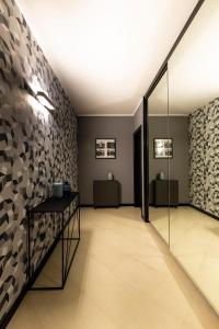 a hallway with a glass door and a wall with brown and gray tiles at LAUS app. 1 - ART & DESIGN nel cuore di Bari - VIA DANTE ALIGHIERI in Bari