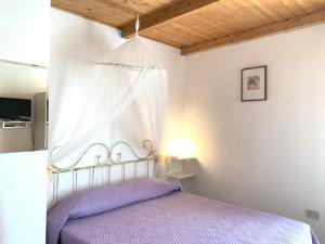 um quarto com uma cama de dossel roxa em B&B S'Incontru em Galtellì
