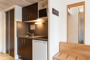 a small kitchen with a sink and a counter at Residhotel Le Grand Prado in Marseille