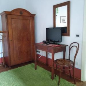 a room with a desk with a television and a chair at Casa - hiša Klarčeva in Ceróglie dellʼErmada