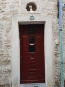 a red door in a stone building with aiership at Pause à Beaucaire avec garage à vélo ou moto in Beaucaire