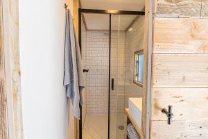 Un baño con ducha con puerta de cristal. en LODGES 7Huizen aan Zee, en Scharendijke