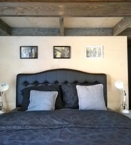 ein Schlafzimmer mit einem blauen Bett mit drei Bildern an der Wand in der Unterkunft Belgian coast 'vakantie-loft' - Klemskerke - De Haan in De Haan