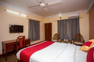 a bedroom with a bed and a desk and a tv at Bandipur Mountain Resort in Bandīpur