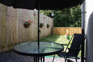 a table with an umbrella and two chairs and a child at Ortari@70 in Bishopston