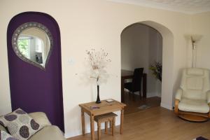 a living room with a vase of flowers on a table at Ortari@70 in Bishopston