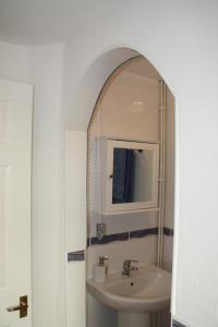 een badkamer met een wastafel en een spiegel bij Ortari@70 in Swansea