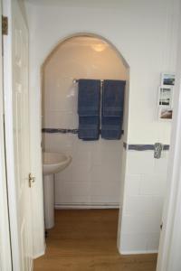 a bathroom with a sink and a shower with blue towels at Ortari@70 in Bishopston