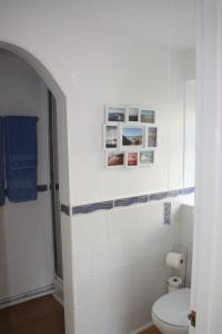 a bathroom with a toilet and pictures on the wall at Ortari@70 in Bishopston