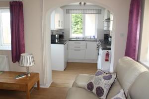 a living room with a couch and a kitchen at Ortari@70 in Bishopston