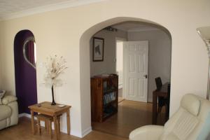a living room with a white couch and a table at Ortari@70 in Bishopston