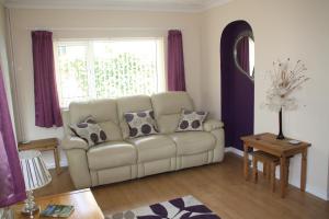 a living room with a white couch and a window at Ortari@70 in Bishopston