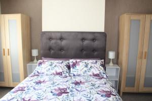 a bedroom with a bed with a floral bedspread at Ortari@70 in Bishopston