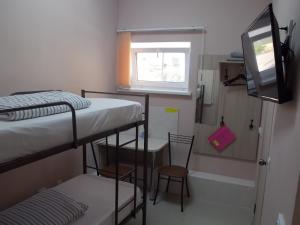 エイスクにあるGuest house Comilfoの二段ベッド2台、テレビが備わる小さな客室です。