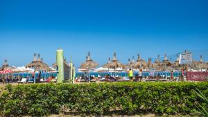 a group of umbrellas and chairs at a beach at Villa On the Sea Le Capannine in Catania