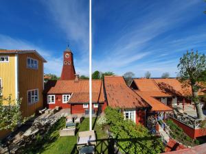 um grupo de edifícios com uma torre de relógio em Gårdshotell Klockargården em Öregrund