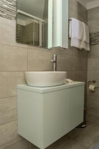 a bathroom with a white sink and a mirror at Meltemi Beach Apartments in Milatos