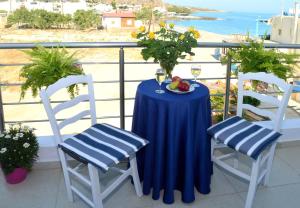 una mesa con 2 sillas y un bol de fruta en el balcón en Meltemi Beach Apartments en Milatos